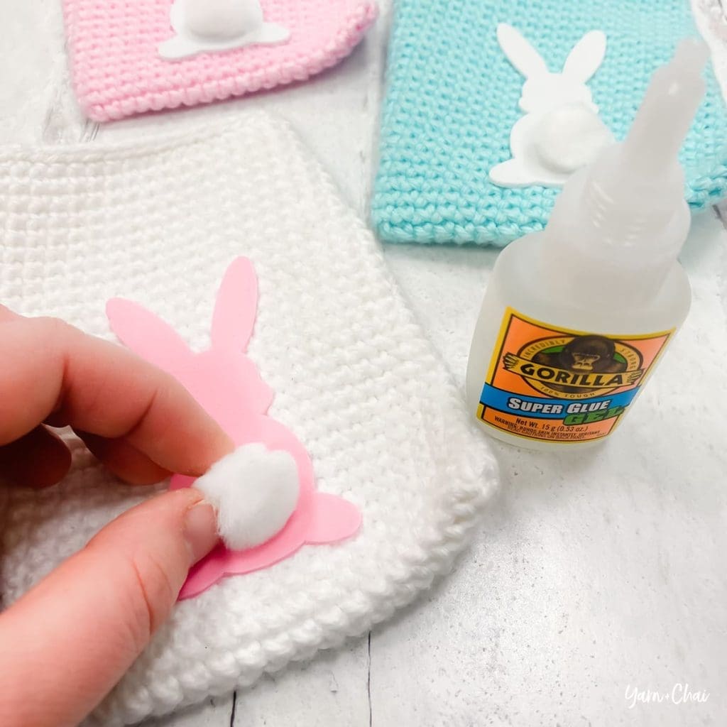 Three easter bunny treat bags surrounded by grass and colorful eggs